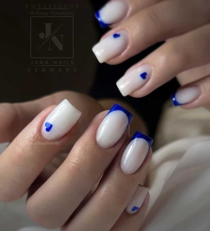 Chic Nail Design: A Sophisticated Blend of Classic and Modern Elements with Bold Blue Tips and Playful Hearts.