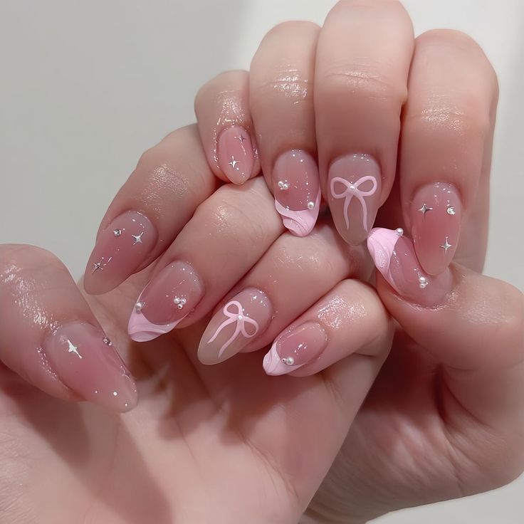 Elegant Soft Pink Nail Design with Whimsical Bows and Sparkles