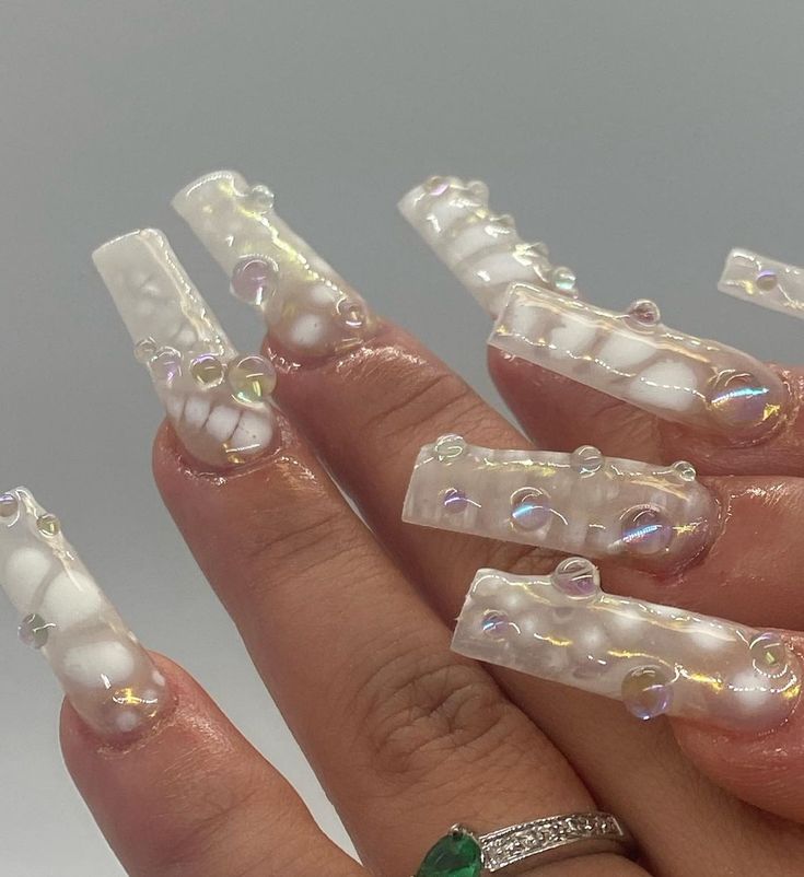 Bold Iridescent Bubble Nail Design with Clear Acrylic Tips and White Swirls.