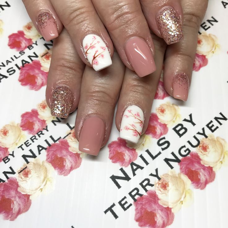 Elegant Pink Nail Design with Intricate Floral Patterns and Sparkling Accents.