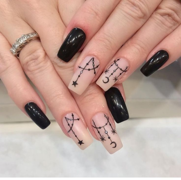 Celestial Nail Art: Elegant Black and Nude Design Featuring Constellations and Moons