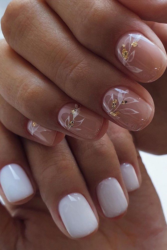 Elegant Nude and White Nail Design with Floral Patterns and Golden Accents.