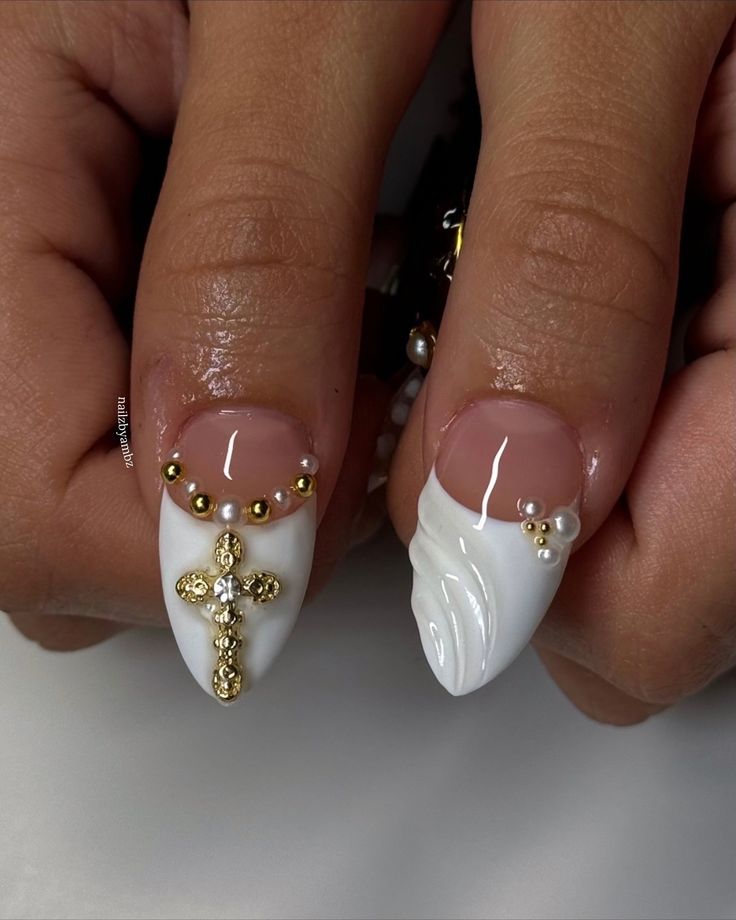 Sophisticated White and Gold Nail Design with Gem-Adorned Cross and Textured Wave Pattern.