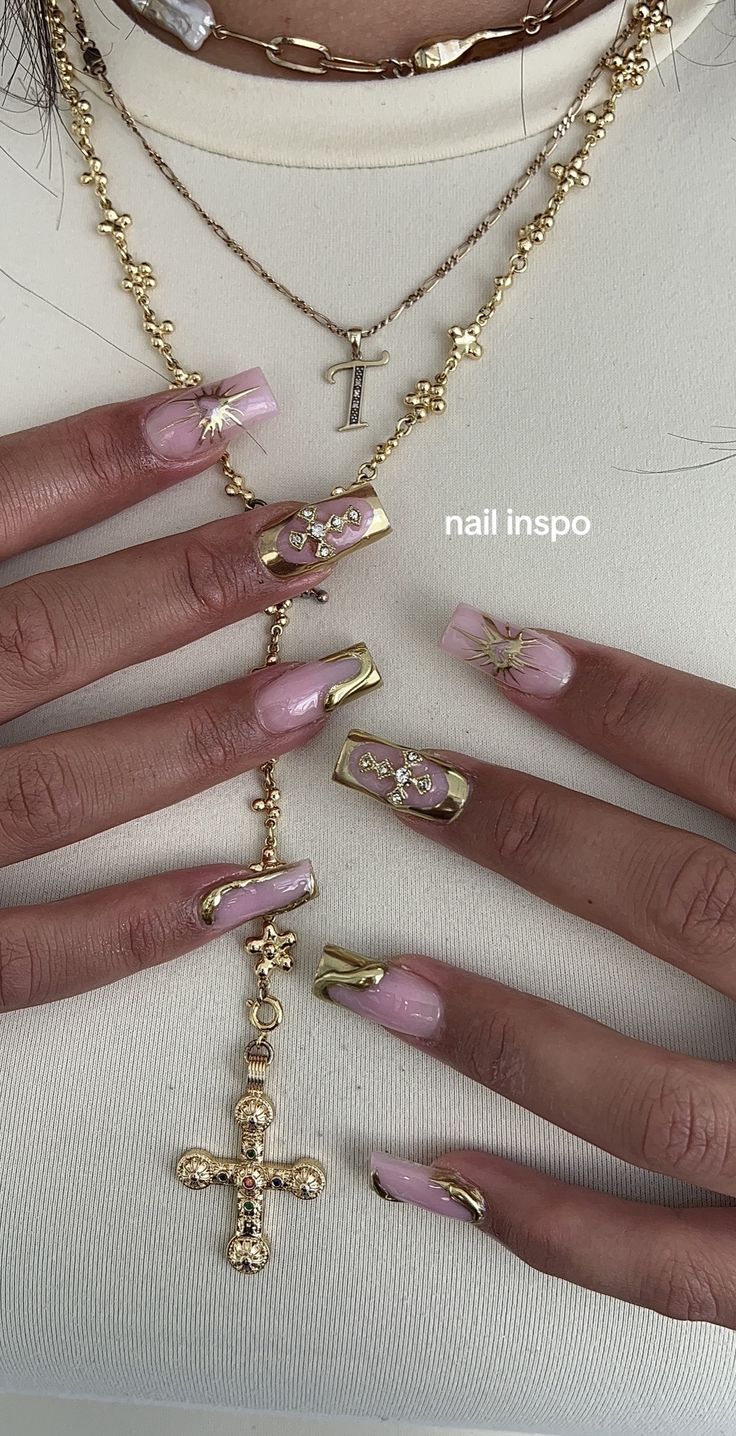 Elegant Soft Pink and Gold Nail Design with Unique Embellishments.