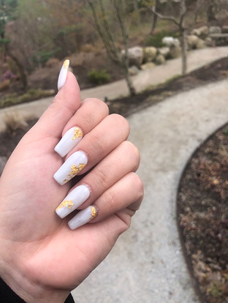 Sophisticated Glossy White Nail Design with Artistic Gold Accents.