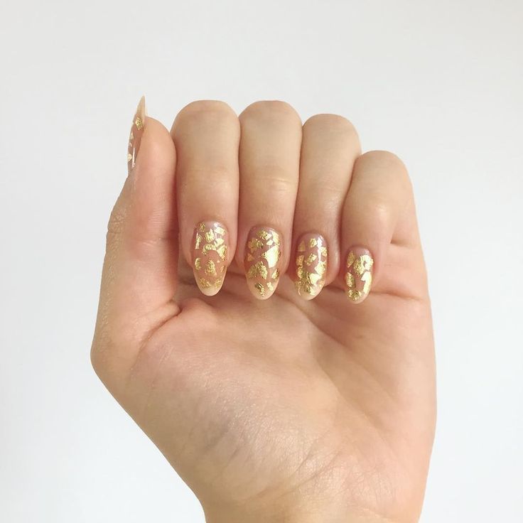 Chic Elegant Nail Design: Soft Pink Base with Intricate Gold Foil Accents and Almond-Shaped Tips.