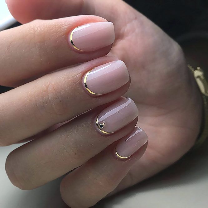 Sophisticated Soft Pink and Gold Nail Design with Shimmer and Gem Accents.