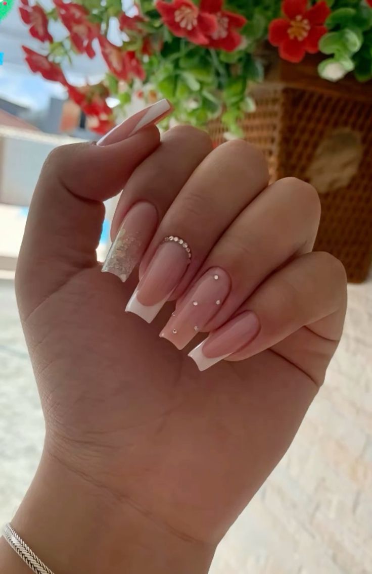 Sophisticated Soft Pink and French Tip Nail Design with Glitter and Pearls.