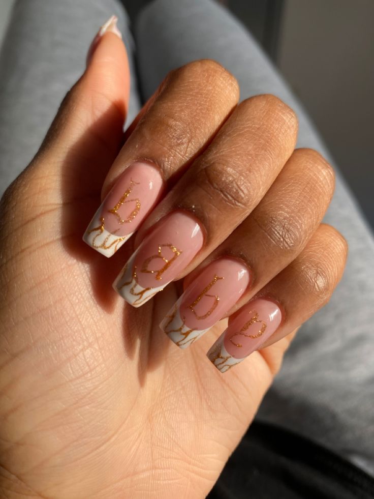 Elegant Contemporary Nail Art with Striking Marble Tips and Gold Accents.