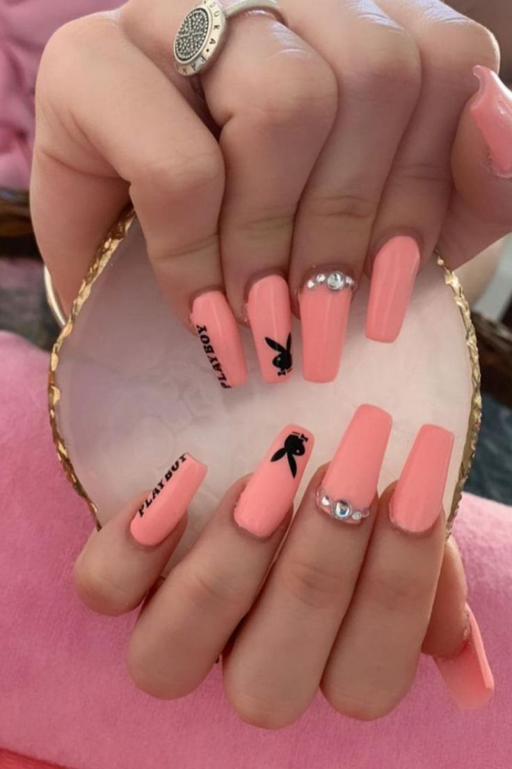 Chic Peach Coffin Nails with Minimalist Bunny Accents and Glamorous Rhinestone Details.