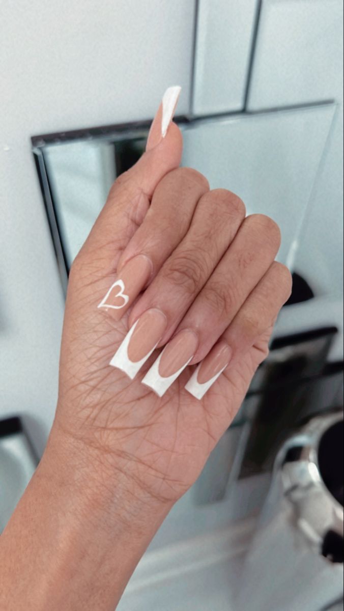 Elegant Chic Nail Design: Glossy Nude Base with Bold White Tips and Playful Heart Accent