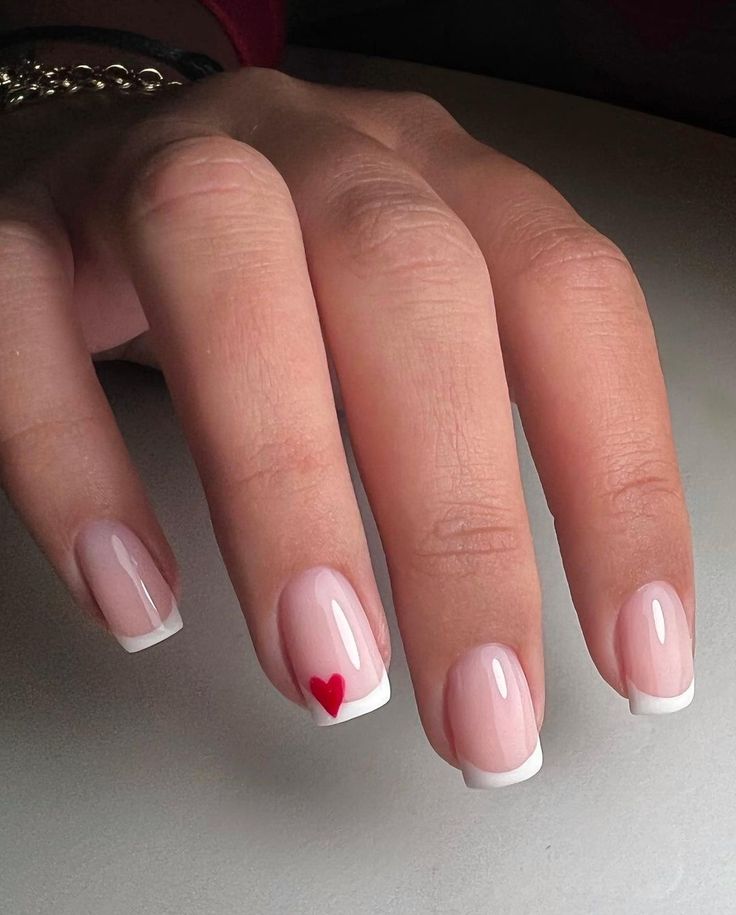 Elegant French Manicure with Whimsical Red Heart Accent for Romantic Flair