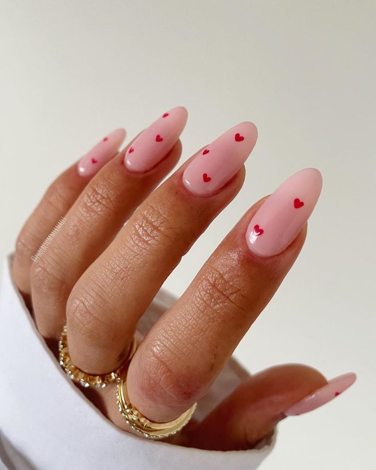 Romantic Soft Pink Nail Design with Delicate Red Heart Accents.