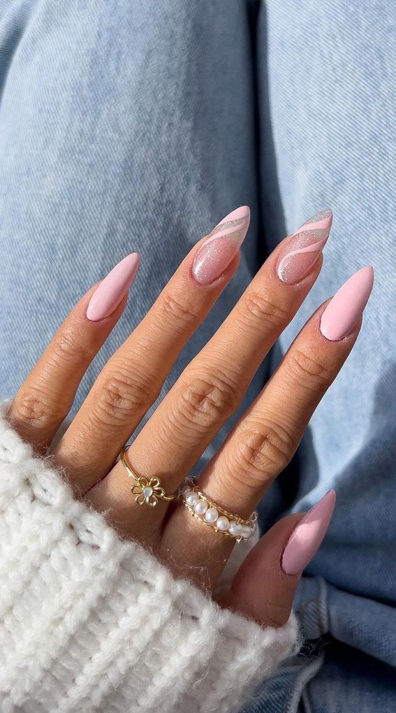 Chic Almond-Shaped Nails with Soft Pink Polish and Silver Accents, Perfectly Paired with Minimalistic Gold and Pearl Rings.