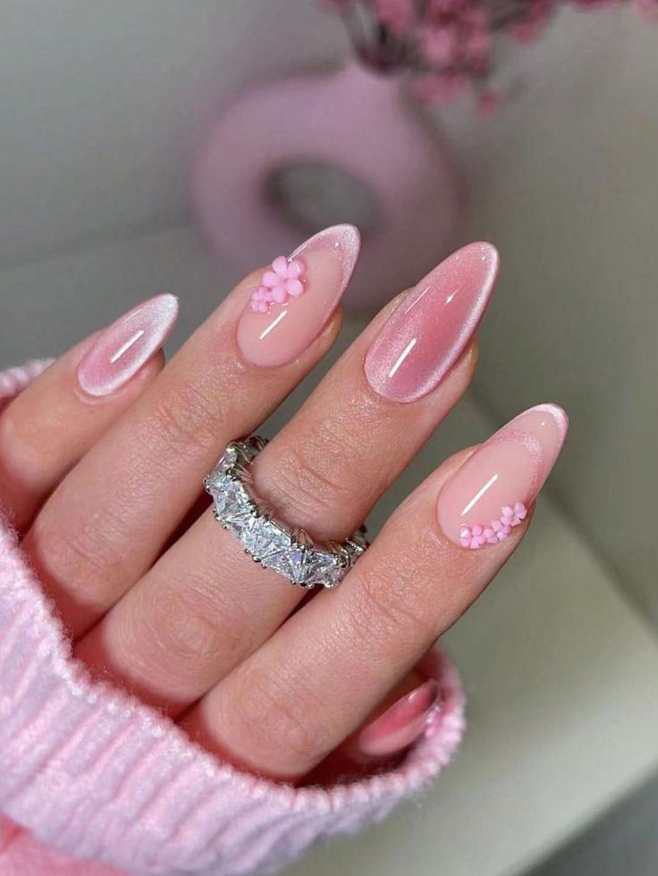 Chic Pink Gradient Manicure with Floral Accents and Stylish Ring.