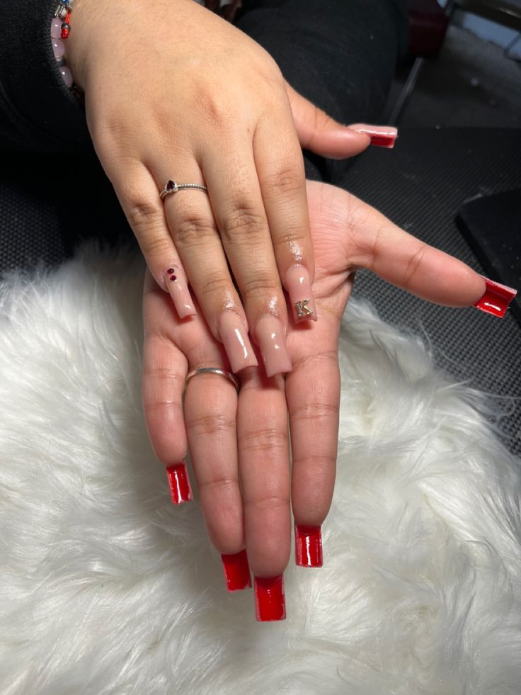 Chic Nail Design: Bold Red Tips on Nude Base with Elegant Embellishments