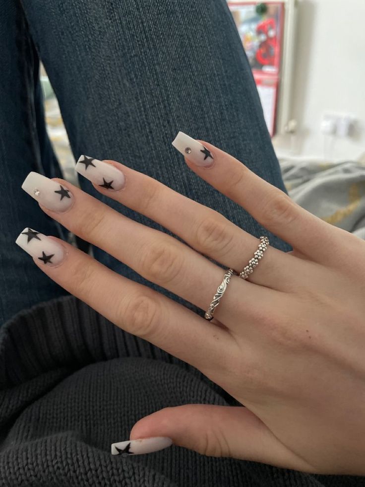 Ombre Nail Design with Intricate Black Stars and Delicate Silver Accents.