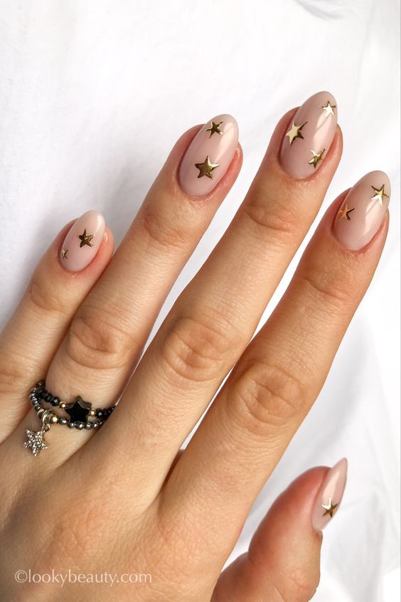 Chic Nude Nail Design with Metallic Gold Star Accents