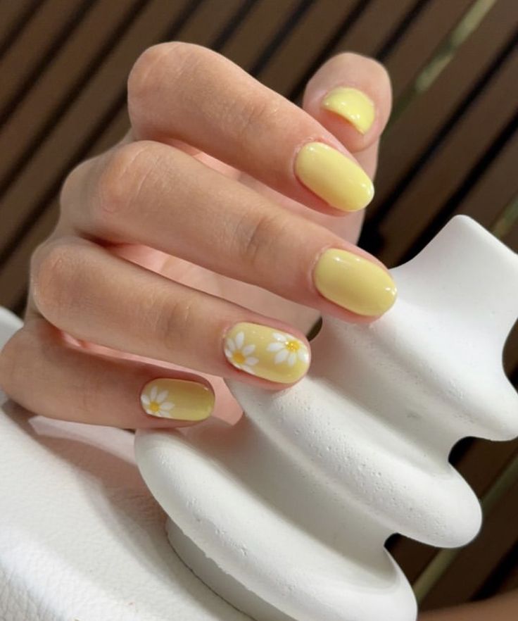 Cheerful Bright Yellow Nail Design with Floral Accents for a Fresh Spring Vibe