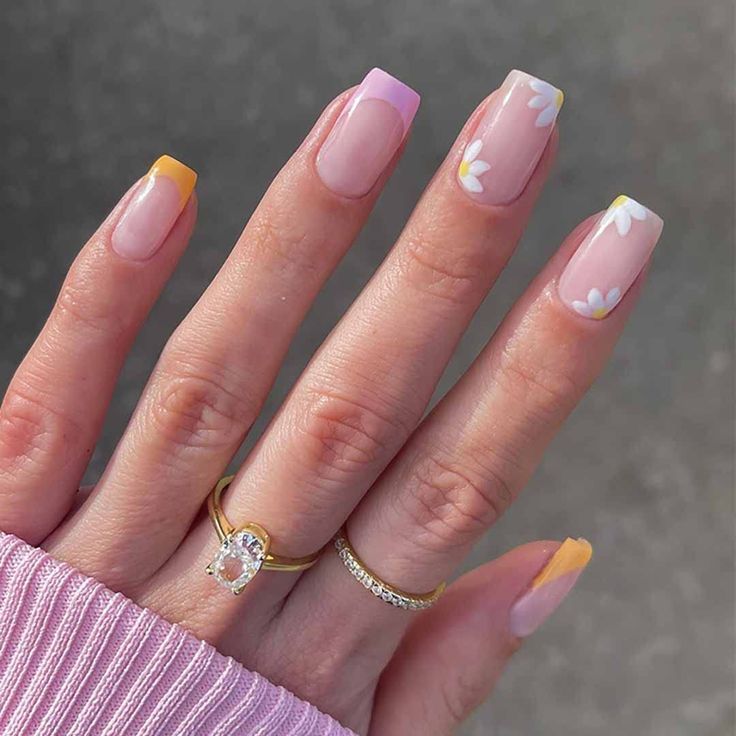 Charming Pastel Nail Design with Floral Accents and Playful French Tips.