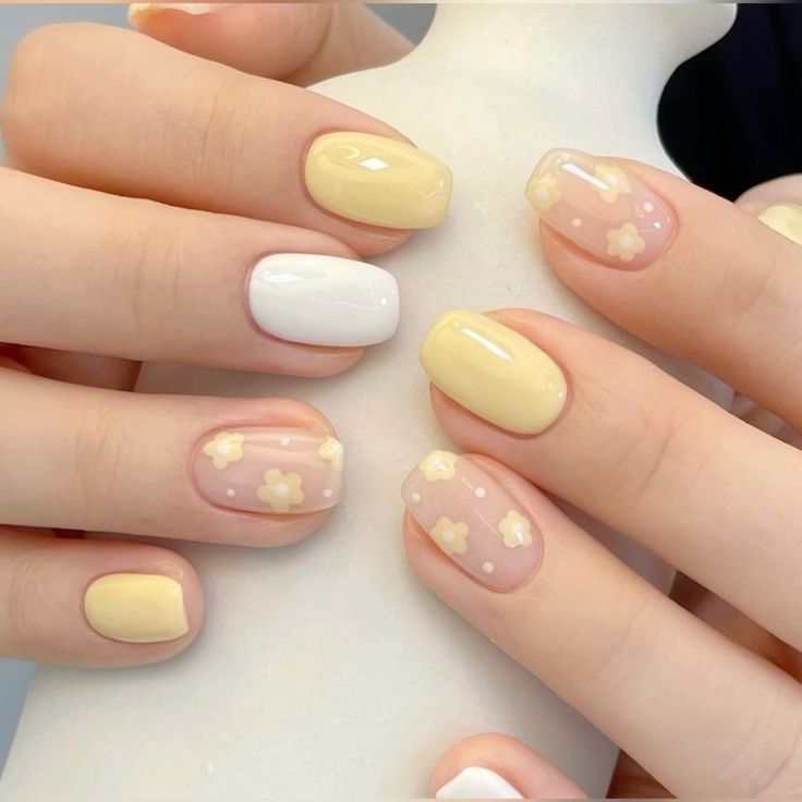 Charming Summer Nail Design: Pastel Yellow and White with Whimsical Floral Patterns.