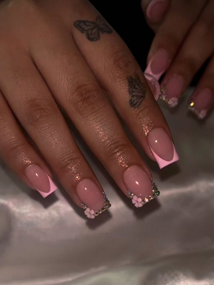 Chic Soft Pink Nail Design with Floral Accents and Sparkling Rhinestones