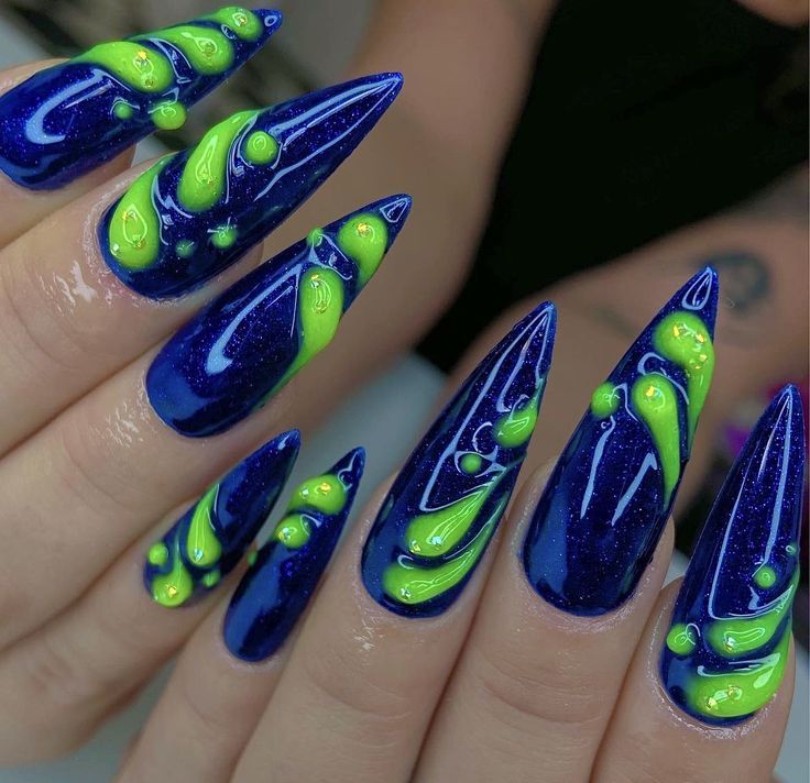 Dramatic Bold Nail Design: Striking Deep Blue, Vibrant Neon Green, and Unique Stiletto Shapes with Glittery Gloss Finish.