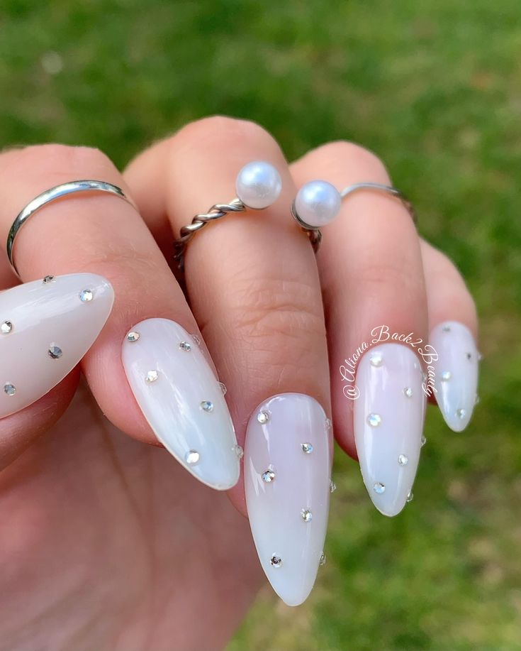 Elegant Translucent White Nail Design with Glossy Finish and Delicate Silver Studs.