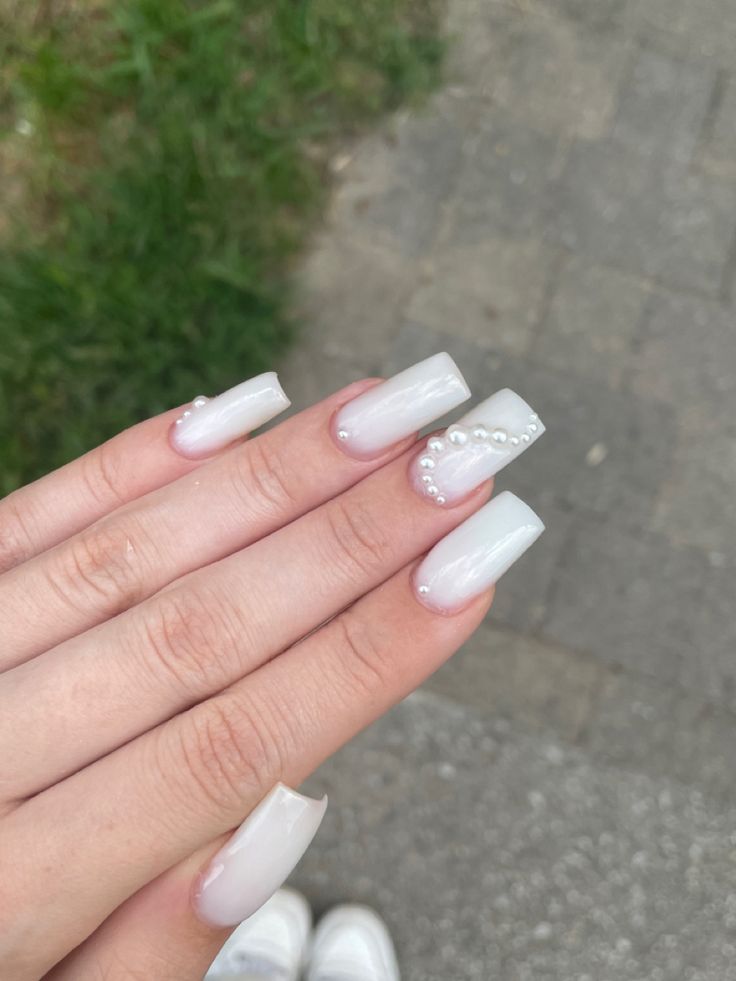 Sophisticated Elegant Nail Design with Glossy White Base and Pearl Accent.