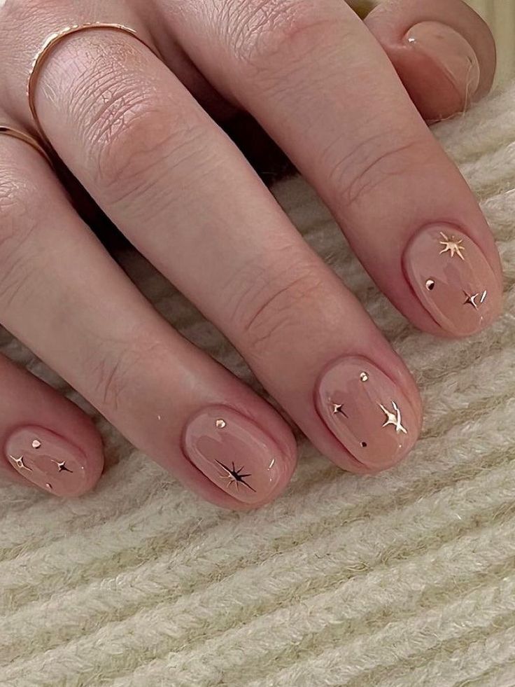 Elegant Nude Nail Design with Delicate Gold Star and Dot Accents