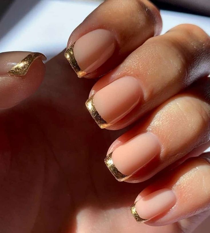 Chic Nude Nail Design with Metallic Gold Accents and Playful Artistic Wave.