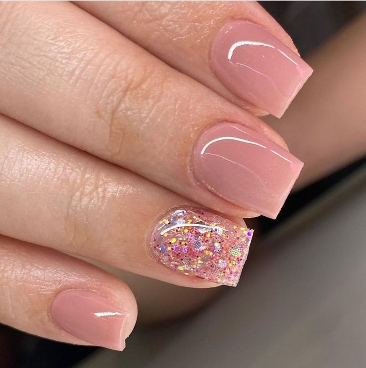 Elegant Pink Nude Nails with Glamorous Glitter Accent for All Occasions.