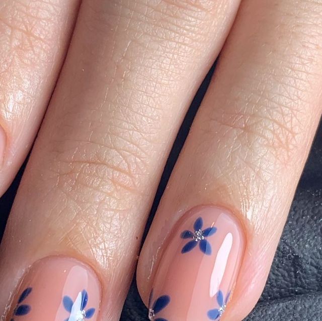 Elegant Floral Nail Design with Peach Tones and Dark Blue Accents.