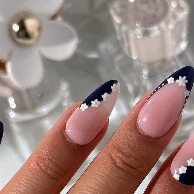 Chic Almond-Shaped Nail Design in Soft Pink and Deep Navy with Floral Accents.