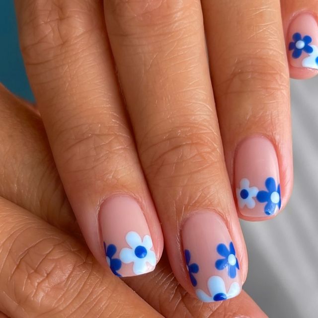 Elegant Floral Nail Design: Delicate Blue and White Flowers on Soft Nude Base