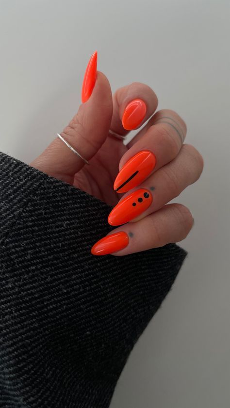 Bold Glossy Orange Nail Design with Sleek Black Accents.