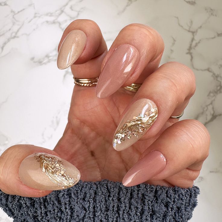 Sophisticated Almond-Shaped Nails with Nude and Pink Shades and Glamorous Gold Accents.