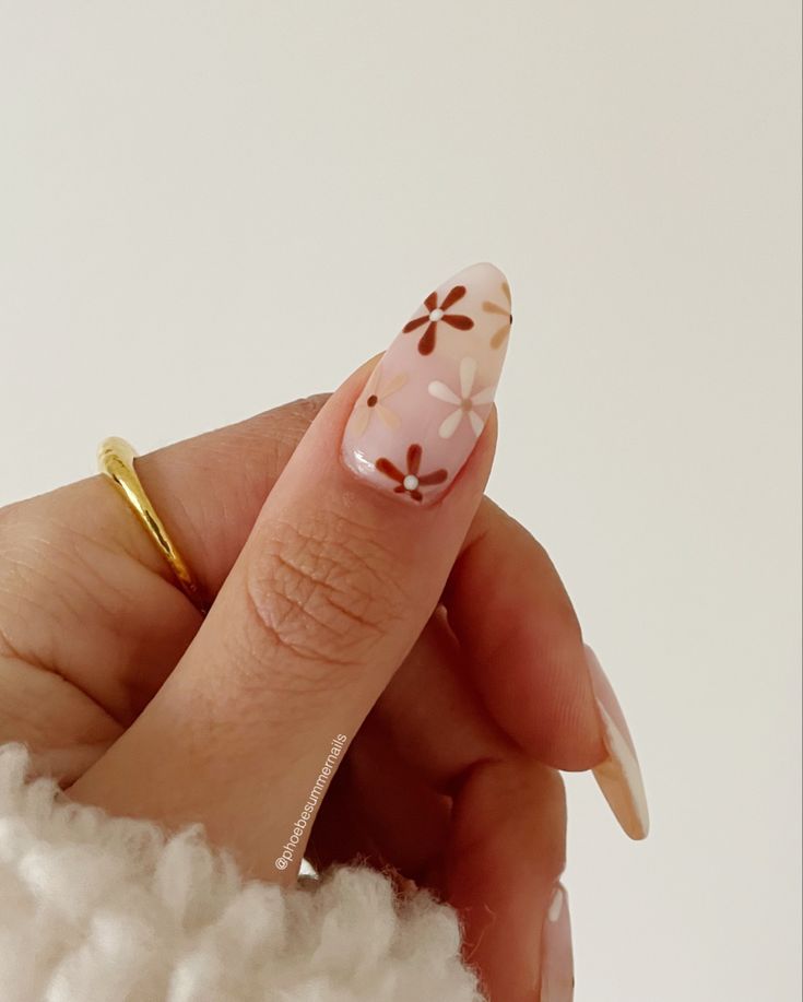 Charming Floral Nail Design: Soft Pink Base with Brown and White Accents for a Spring-Inspired Elegance.