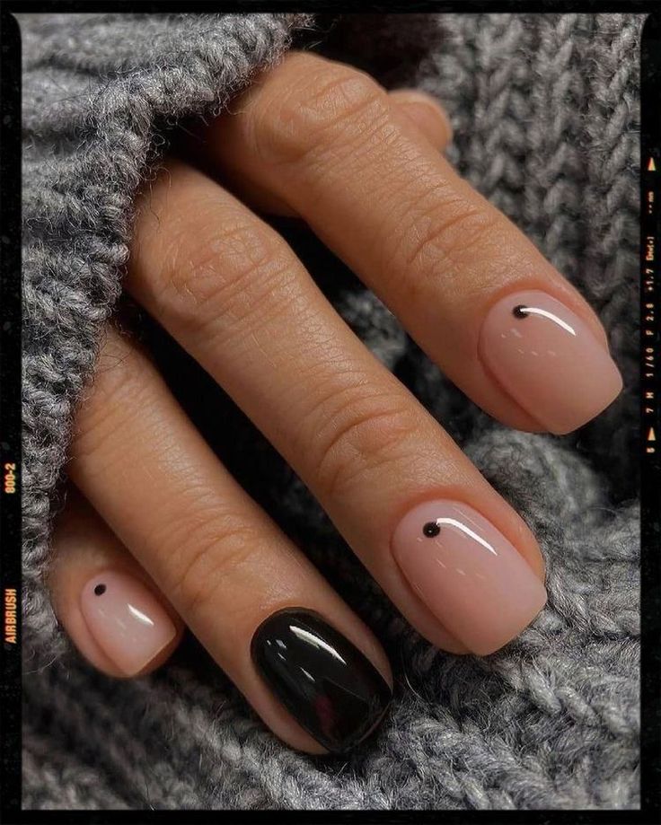 Sophisticated Nail Design: Soft Nude and Bold Black with Minimalist Accents.