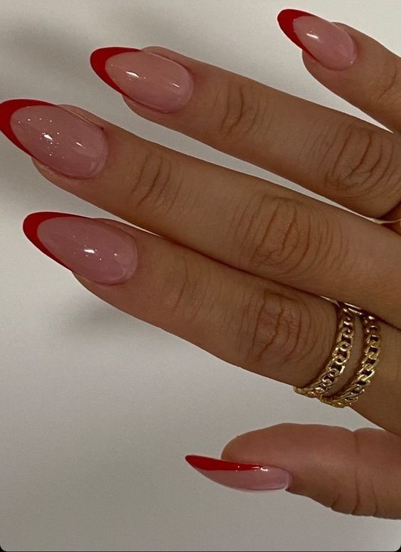 Elegant French Tip Nail Design: Bold Red Tips on Soft Nude Base.