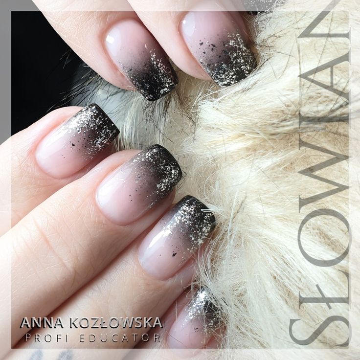 Sophisticated Ombre Nails: Nude Base with Chic Black Tips and Glitter Accents.