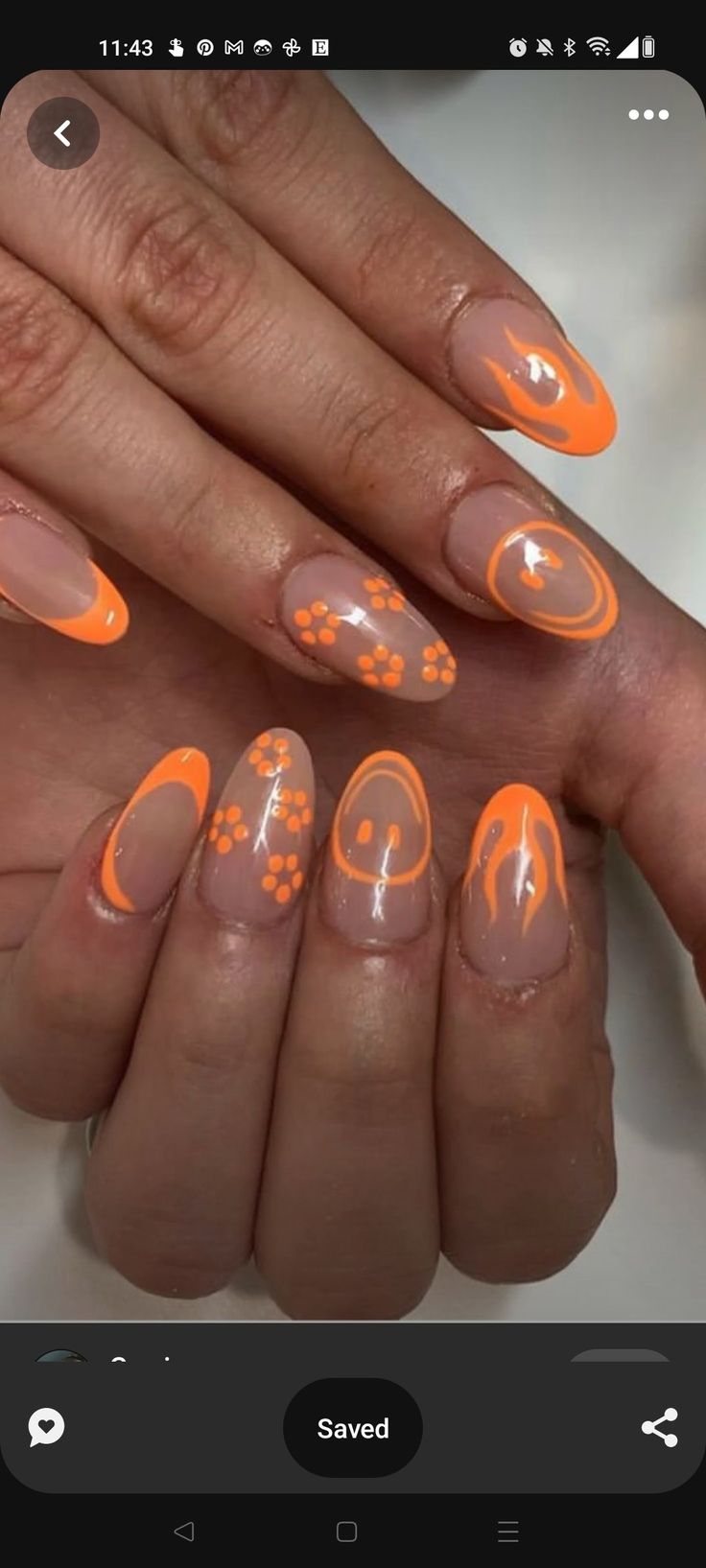 Cheerful Nail Art: Vibrant Orange and Nude Tones with Playful Floral and Smiley Designs.