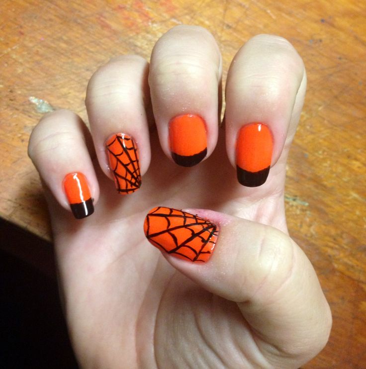 Playful Halloween Nail Art: Vibrant Orange with Spiderweb Motif and Sleek Black Tips.