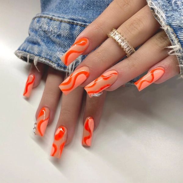 Bold Vibrant Orange Nail Design with Wavy Patterns for Striking Visual Impact.