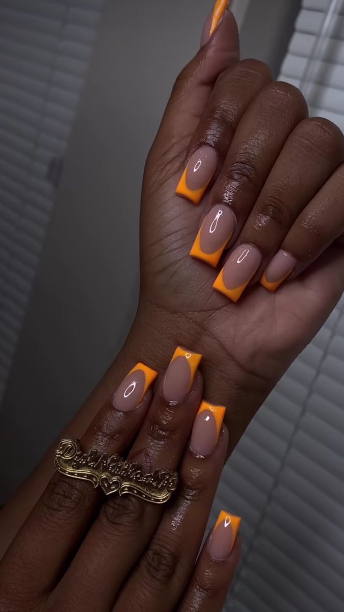 Bold Orange Tips on Nude Base: A Chic and Elegant Nail Design.