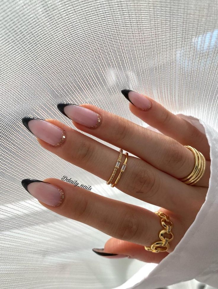 Chic Blush Nail Design with Elegant Black Tips and Glamorous Rhinestone Accents.