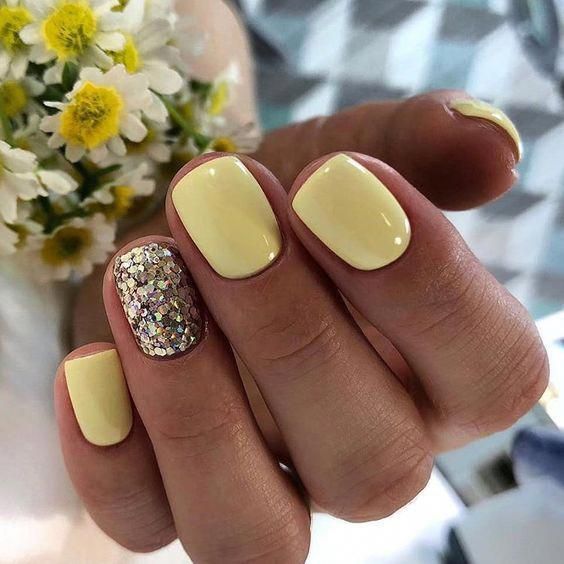 Cheerful Yellow Nail Design: A Blend of Smooth Pastels and Vibrant Glitter.