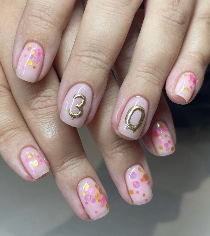 Vibrant Pink Confetti Nail Design with Personalized Gold Number Accents for Celebratory Elegance.