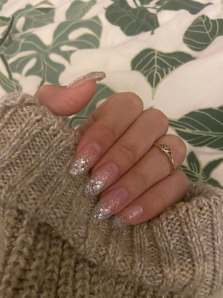 Enchanting Glittery Ombre Nails: A Soft Pink to Sparkling Silver Transition Pairing Perfectly with Cozy Knitwear.