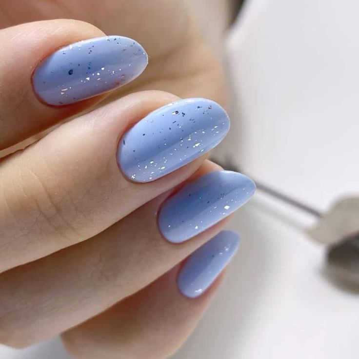 Elegant Soft Blue Oval Nails with Matte Finish and Sparkling Silver Glitter.